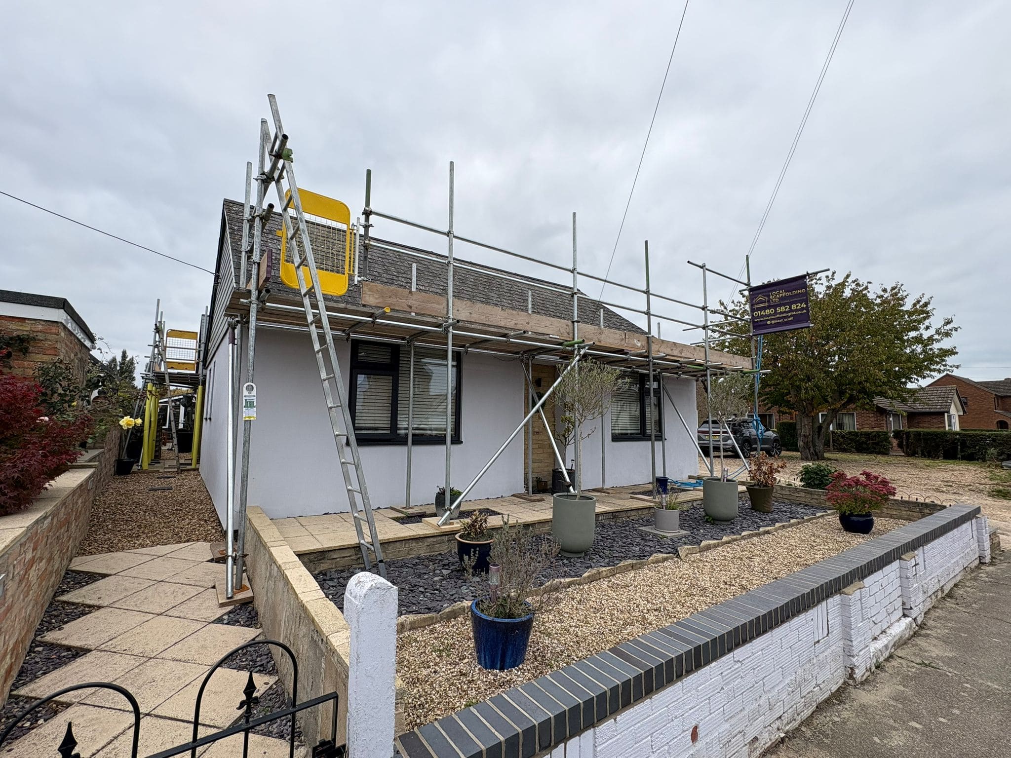 Residential scaffold around a rendered single-storey bungalow with Local Scaffolding Ltd branded banner
